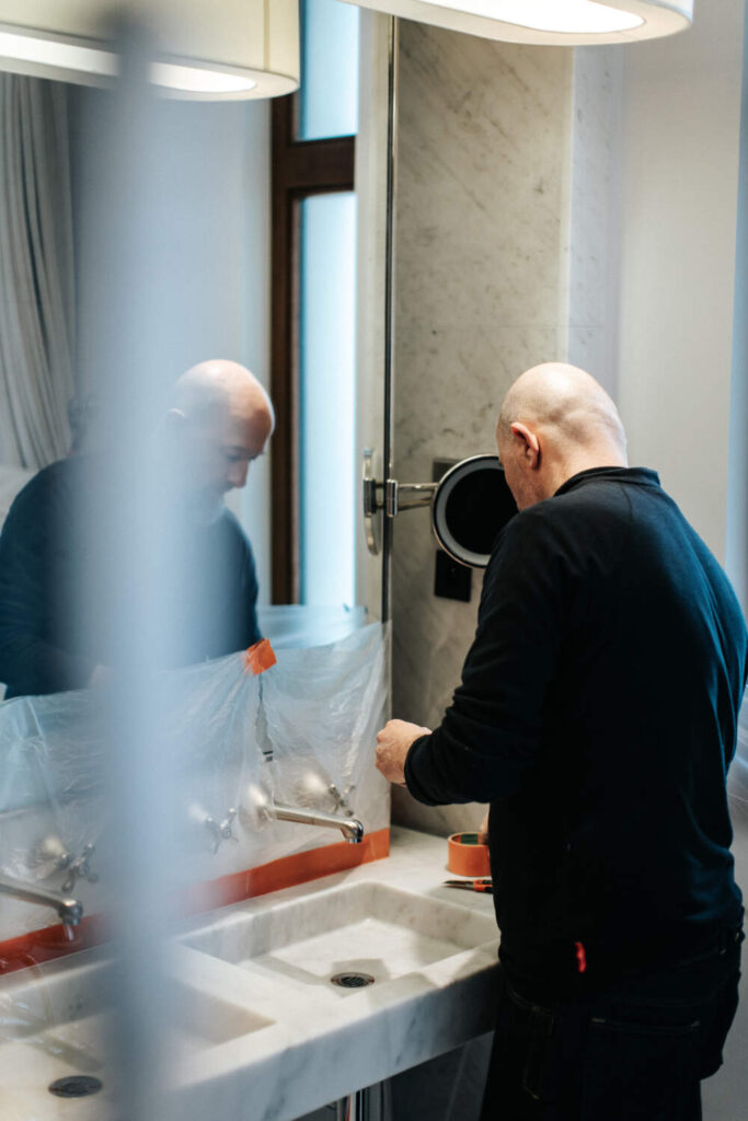 Photo d'un artisan de l'entreprise PC MARBRE entrain de rénover un évier de salle de bain en marbre